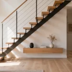 Escalier sans contremarche dans un intérieur contemporain avec un aménagement bas et discret sous les marches, laissant circuler la lumière naturelle.