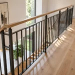 Hauteur de garde-corps pour escalier : ce que dit vraiment la norme NF P01-012 Escalier intérieur contemporain équipé d'un garde-corps avec main courante et barreaux verticaux, illustrant une installation conforme aux exigences de hauteur réglementaire.