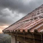 Temps de séchage anti-mousse: le délai réel à respecter avant la pluie Pluie battante sur une toiture en tuiles illustrant le risque de lessivage d'un traitement anti-mousse avant la fin du temps de séchage.