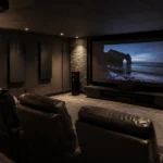 Salle de cinéma privée aménagée dans un sous-sol avec grand écran de projection, fauteuils inclinables, murs acoustiques sombres, éclairage tamisé et ambiance immersive dédiée au home cinéma.