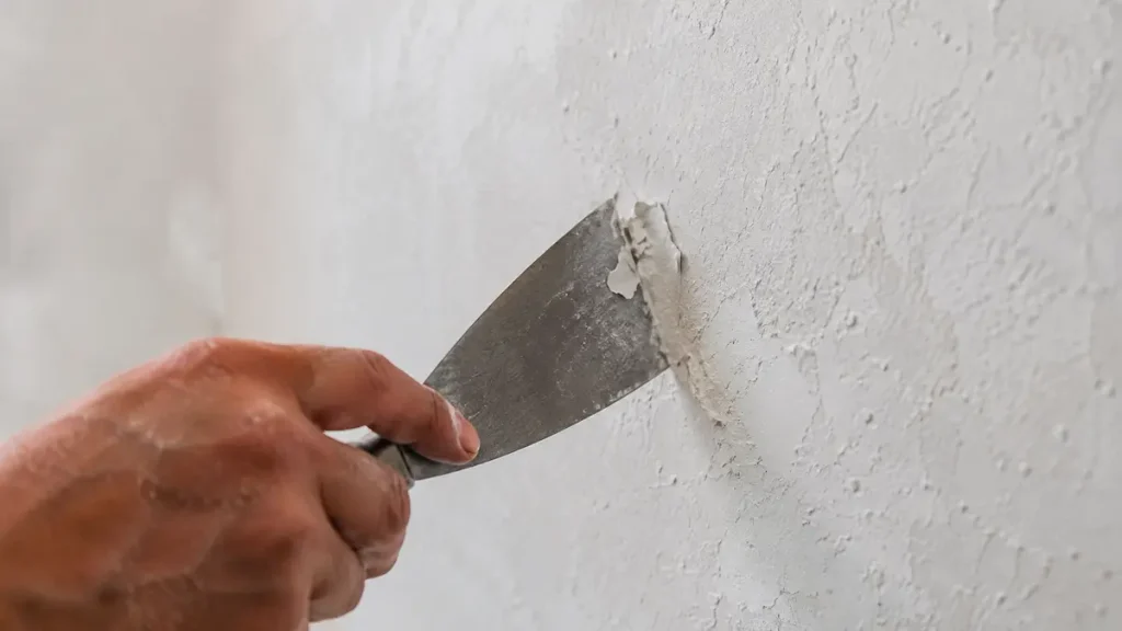 Test de l’adhérence d’une peinture murale à la spatule avant rénovation